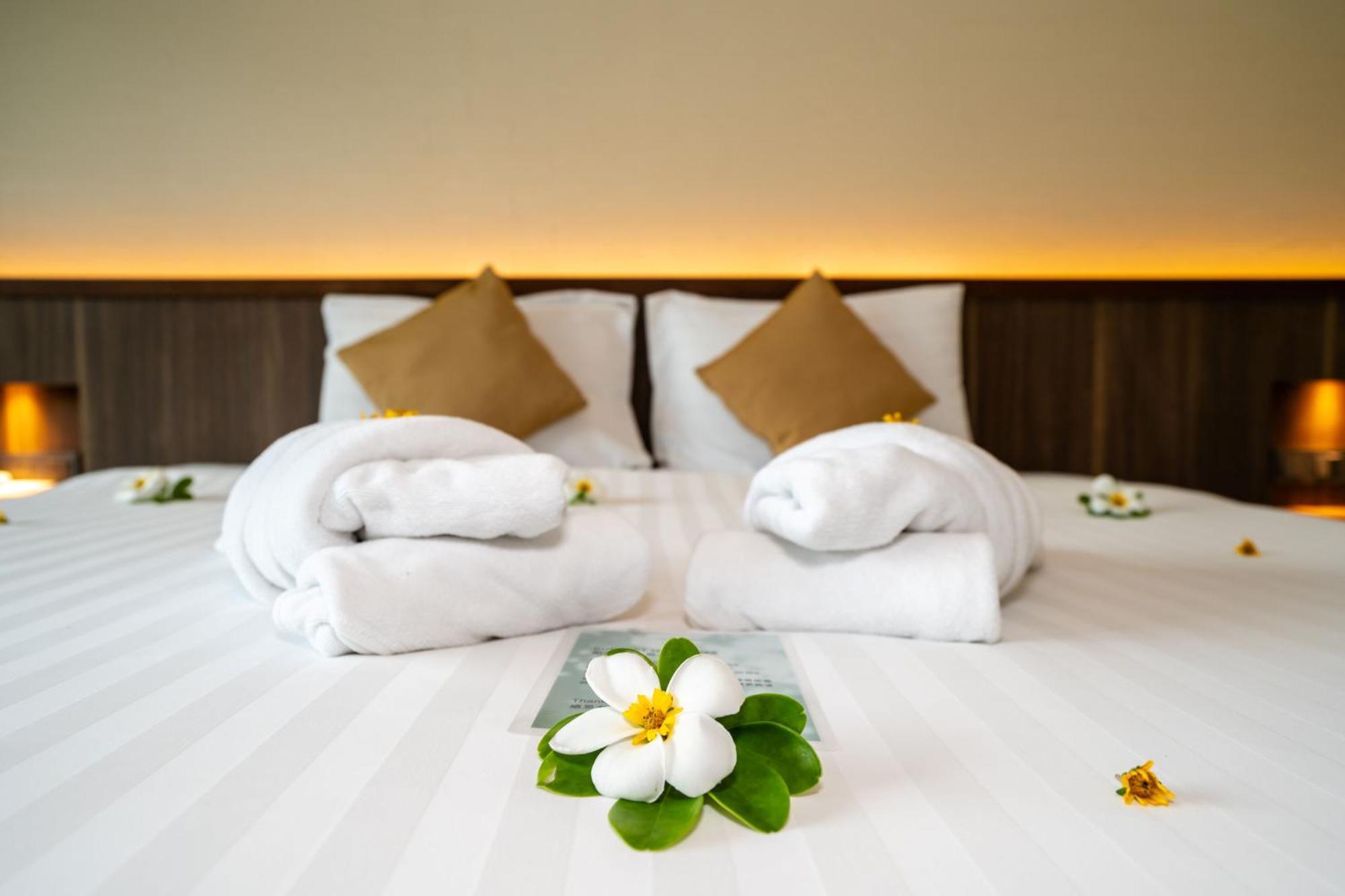 Le Resort And Villas Rawai Екстер'єр фото A bed with towels and flowers